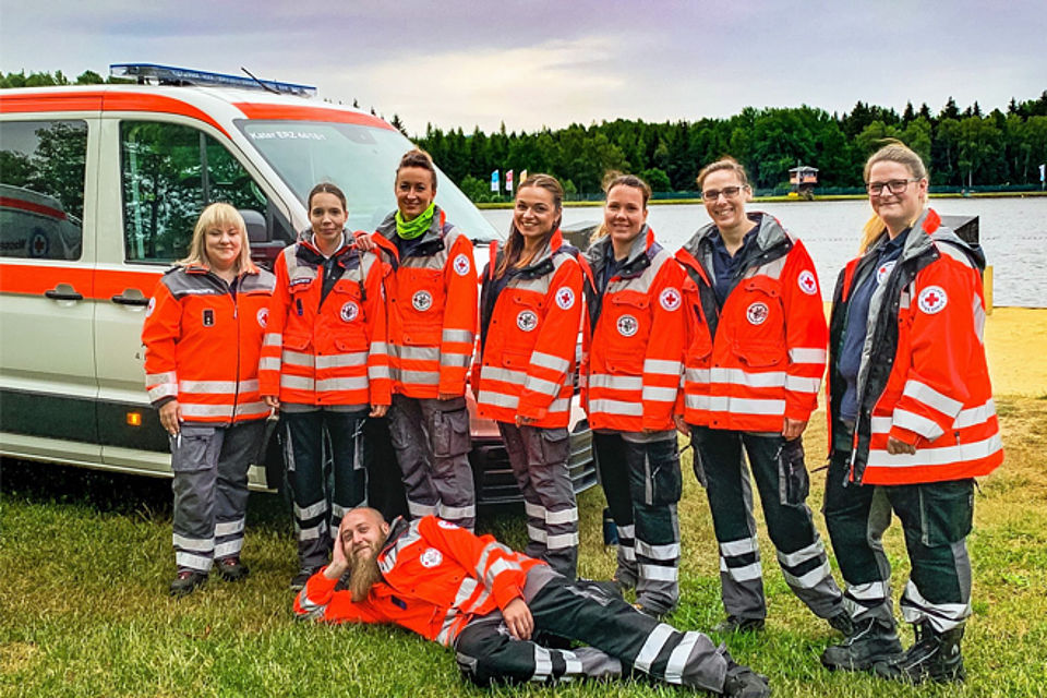 Mitglieder der Rettungshundestaffel vor ihrem Fahrzeug