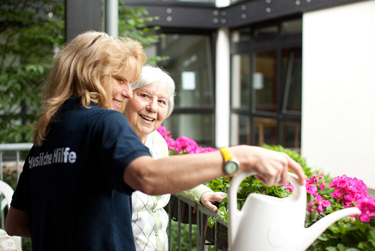 Pflegekraft beim Blumengießen