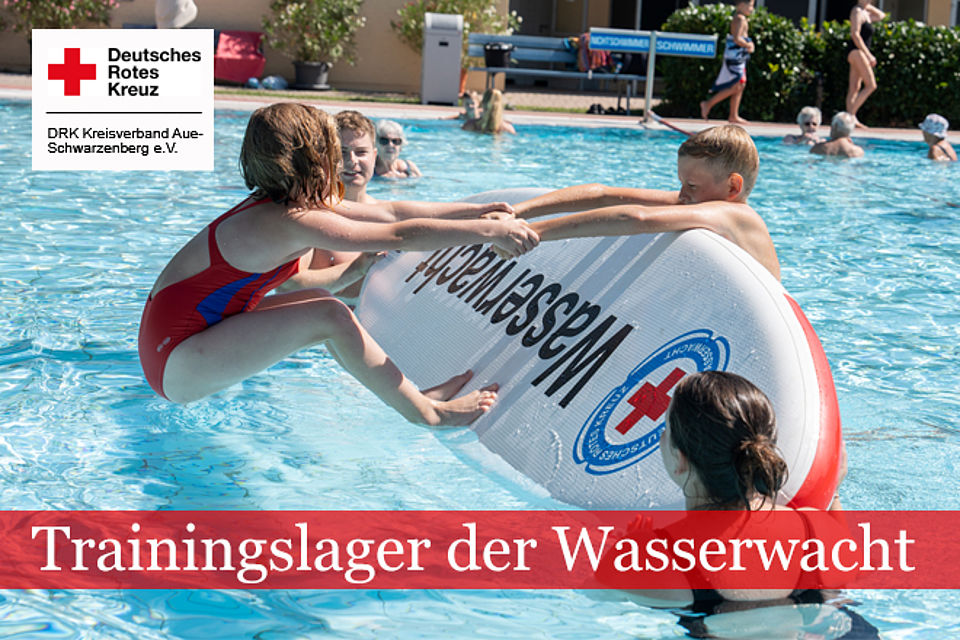 Zwei Kinder im Freibad mit einem Rettungsbrett der Wasserwacht